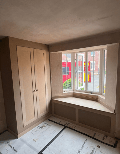 Custom fitted wardrobe and bench in front of a window by our carpenter in Blackwood